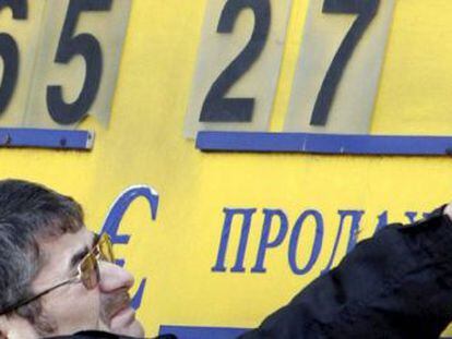 Un trabajador de una oficina de cambio coloca unas placas para formar las cifras del cambio d&oacute;lar-rublo en Mosc&uacute;, Rusia.