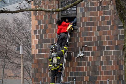 Un bombero rescata a varias personas atrapadas en el edificio. 
