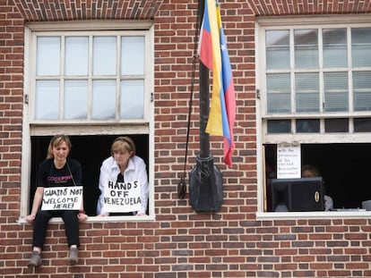Acivistas con carteles contra el líder de la oposición venezolana Juan Guaidó. 