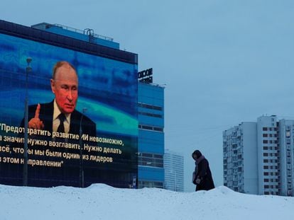 Una mujer pasa junto a una pantalla que muestra la cita anual con la prensa de Vladímir Putin, en Moscú (Rusia), este jueves.