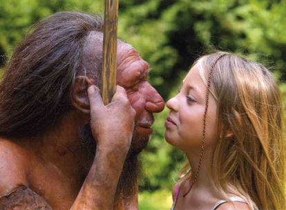 Una niña observa una figura que recrea la fisonomía atribuida al neandertal en un museo.