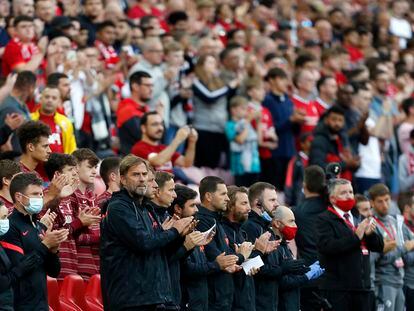 Juergen Klopp y sus asistentes aplauden en la banda durante el homenaje a Michael Robinson en Anfield.