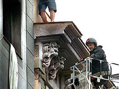 Los bomberos rescatan a uno de los inquilinos del piso siniestrado.