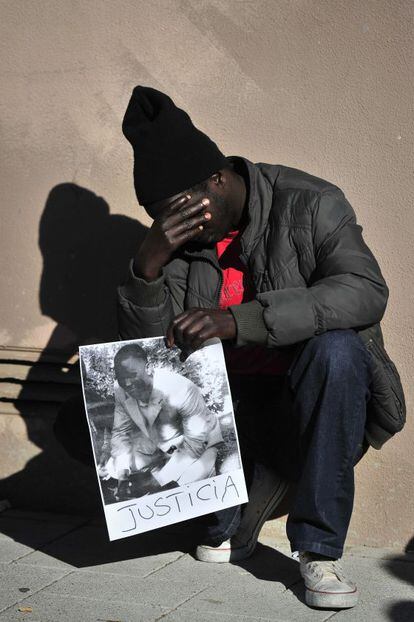 Un senegalés con la foto de su compatriota asesinado.