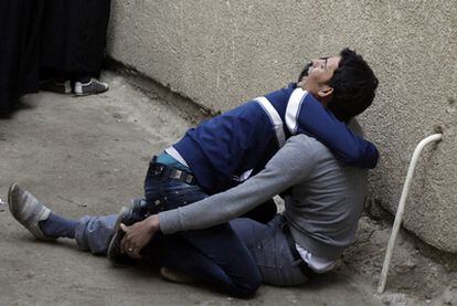 Dos jóvenes lloran en la puerta de la morgue donde está el cadáver de un familiar muerto en el atentado en Ciudad Sáder, al este de Bagdad.