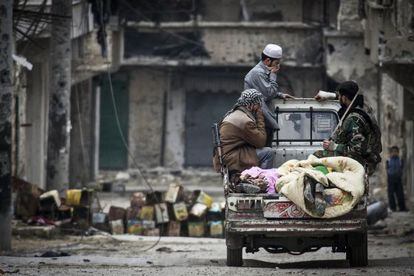 Soldados del Ej&eacute;rcito Libre Sirio cubren dos cuerpos en Alepo, tras enfrentamientos con las tropas del Gobierno.