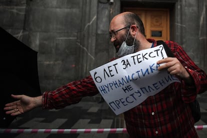 Ilyá Azar con un cartel que dice "El periodismo no es un crimen", en una protesta el viernes en la que fue arrestado.