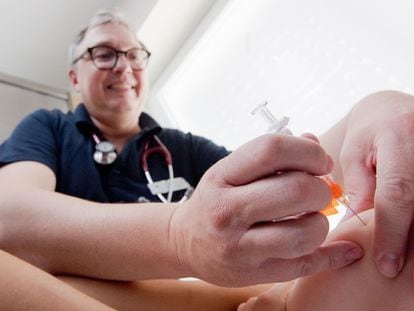 Un niño es vacunado frente al sarampión por personal sanitario.