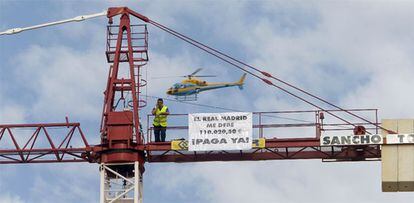 El trabajador, que reclama al Real Madrid un a deuda de 102.020 euros, sobre la grúa de un edificio en construcción en Valdebebas.