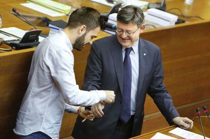 El diputado Fran Ferri coloca una pulsera reivindicativa LGTB al presidente Ximo Puig.