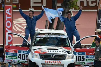 El conductor Juan Gabriel Abarca (d) y su copiloto Juan Varela de Argentina con su bandera nacional a la salida.