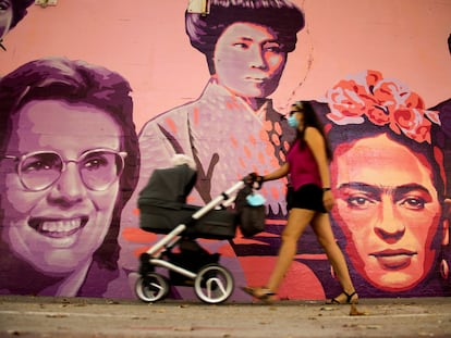 Una mujer camina junto al mural restaurado de las mujeres del barrio de Ciudad Lineal en Madrid, este sábado.