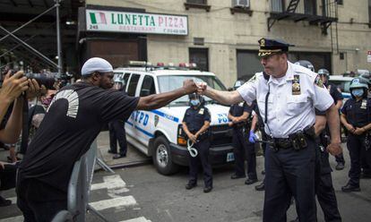 Un mando del departamento de Policía de Nueva York saluda a los manifestantes durante la marcha de protesta del martes por el asesinato de George Floyd.