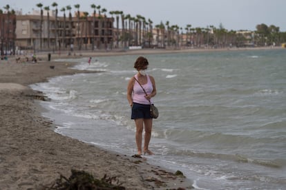 Una vecina de Los Alcázares camina por la orilla del mar Menor.