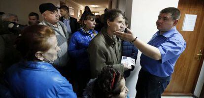 Varias personas esperan para obtener el pasaporte ruso, este jueves en una oficina de Simferópol.
