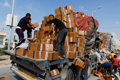 Varios palestinos cargan un camión con suministros de socorro este jueves en Rafah, en el sur de la Franja de Gaza.