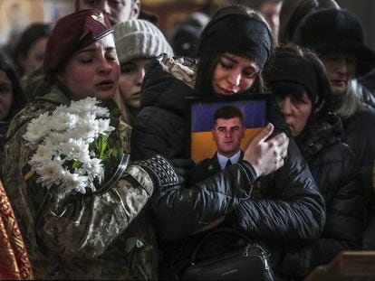Una mujer abraza la foto de un soldado ucranio muerto en el frente, durante un funeral por tres de ellos en la iglesia de los Apóstoles Pedro y Pablo, en Lviv, el 9 de marzo.