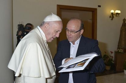 Francisco y Vidal hojean el libro con los artículos del Papa y, después, el dossier MCSPA.