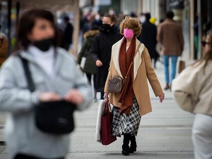 Varias personas con mascarilla pasean por una calle de Madrid.