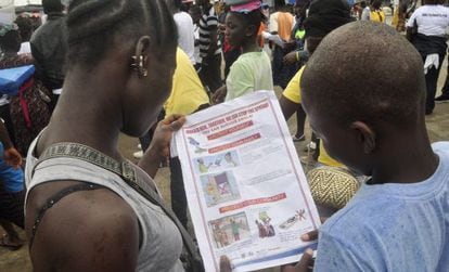Niños liberianos leen un folleto para protegerse del ébola, en Monrovia.
