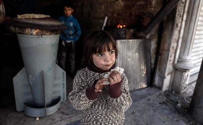Una niña come pan elaborado en un horno hecho con restos recogidos de un cohete.