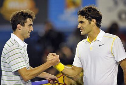 Gilles Simon y Roger Federer se dan la mano tras el partido de segunda ronda.