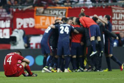 Los jugadores de Atlético celebran el pase a la final mientras Xabi Alonso se lamenta en el suelo.