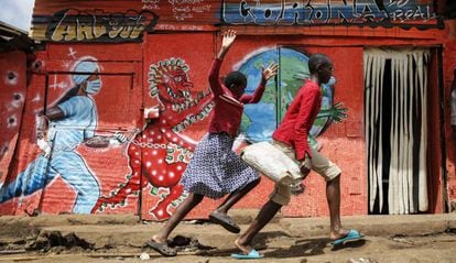 Unos niños corren por delante de un mural que previene de los peligros de la covid-19 en Nairobi, Kenia, el 3 de junio de 2020.   