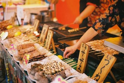 Fukuoka (Japón) es el nuevo destino alternativo para los amantes de la cocina japonesa. Esta ciudad, una de las más antiguas del país, se ha convertido en una de las grandes capitales gastronómicas de Asia. Es también la metrópoli japonesa que más rápido crece, convertida en un centro de negocios y de comercio internacional. En los últimos años se ha convertido además en una nueva etapa para viajeros internacionales que se animan a descubrir el país más a fondo. Entre los hitos para saborear la ciudad están el único mercado de pescado público de Fukuoka, Yanagibashi, y el centro comercial subterráneo de Tenijin Chikagai, con dos pasillos que se extienden medio kilómetro por debajo de la céntrica zona de Tenijin. Allí hay más de 159 tiendas con todo tipo de productos, pero también muchos restaurantes y puestos de alimentos en los niveles inferiores. El plato más popular es el 'hakata ramen', una sabrosa y adictiva sopa de fideos. Pocos pasos al norte de Tenjin Chikagai se halla uno de los restaurantes de ramen más famosos de la ciudad, Shin Shin, donde siempre hay cola. La alternativa es Hacchan, donde los clientes hacen el pedido mediante una máquina, buscan asiento y esperan a que les traigan su bol. La capital de la isla de Kyūshū es también cuna del genuino 'shōchū', una bebida espiritosa japonesa que marida de maravilla con la cocina local. Un lugar para probarlo es el bar Oscar. Y entre comida y bebida todavía hay tiempo para recorrer Fukuoka: su famoso castillo, de 1600, el Museo de las Ruinas de Korokan, el santuario sintoísta de Gokoku o el popular parque Ohori, presidido por un coqueto estanque rodeado por un sendero y puentes de piedra que conectan los islotes. De obligada visita es también el parque Ohori-koen, con cascadas y flora perenne con el exquisito diseño de los jardines japoneses.