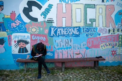 Una joven sentada frente al mural de un hogar de acogida en Bolivia para niñas y adolescentes víctimas de trata.