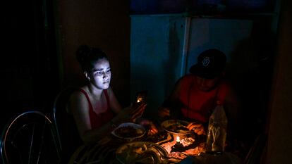 Una mujer ilumina su cena con su teléfono móvil durante un apagón en La Habana, en mayo de este año.