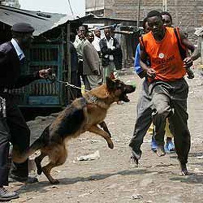 Un policía keniano y unos presuntos delincuentes, en la operación contra una secta criminal ayer en Nairobi.