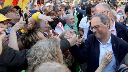 El presidente de la Generalitat, Quim Torra, (derecha), saluda a asistentes de la manifestaci&oacute;n este s&aacute;bado en Madrid. 