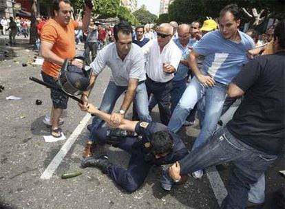 Un antidisturbios es golpeado por algunos manifestantes tras la carga realizada por la Policía Nacional contra los agricultores almerienses ante la Delegación de Hacienda.