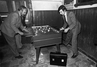 El ministro de Sanidad y Consumo, Ernest Lluch (a la derecha), jugaba al futbolín con un colaborador en un restaurante de Madrid tras la reunión del Consejo de Ministros, el 2 de febrero de 1983. En el suelo, el maletín de ministro.