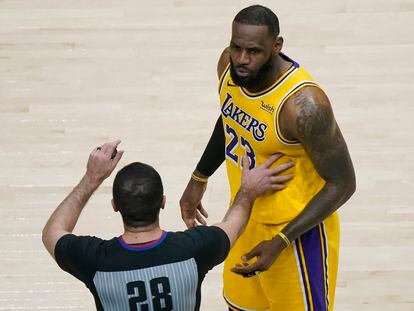 Uno de los árbitros separa a LeBron James de los aficionados con los que mantuvo una discusión durante el Hawks-Lakers.
