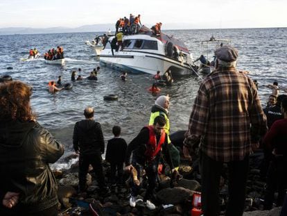 Residentes de la isla griega de Lesbos ayudan a unos refugiados a desembarcar. 