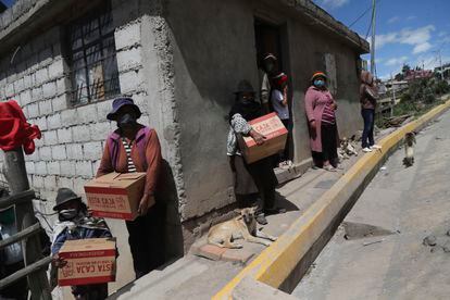 Vecinas de las afueras de Quito reciben las cajas de alimentos repartidas por el Gobierno durante la cuarentena.