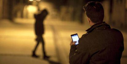 Un joven env&iacute;a un mensaje con su tel&eacute;fono m&oacute;vil. 