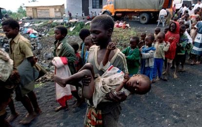 Un niño traslada en brazos a otro menor, desfallecido, a su llegada a un orfanato cerca de Goma, antiguo Zaire, el 19 de julio de 1994.