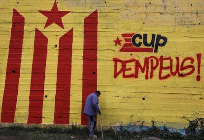 Un hombre camina frente a un grafiti de una bandera independentista, en Manresa (Barcelona).