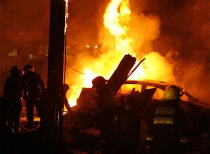 Bomberos mexicanos intentan apagar el fuego en la avioneta siniestrada.
