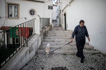Un vecino pasea por la Alfama, el barrio más antiguo de Lisboa y con mayor número de pisos turísticos.