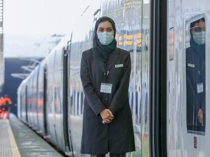 Una empleada de Renfe junto a un tren de la línea Haramain, en Arabia Saudí.