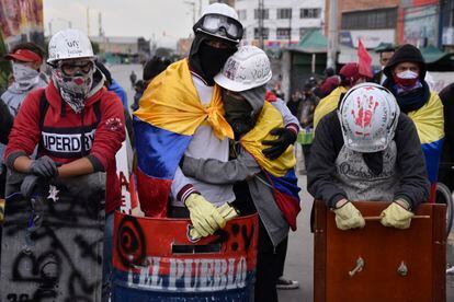 Miembros de la primera línea se abrazan durante una protesta contra el Gobierno de Iván Duque, en Bogotá, el 28 de mayo de 2021.