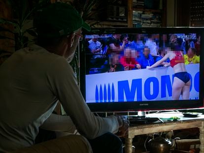 Un hombre mira contenidos de deporte femenino en YouTube en una televisión inteligente.