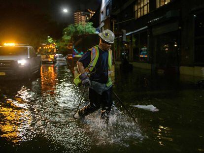 Un trabajador desbloquea los desagües en una calle afectada por las inundaciones en Brooklyn, Nueva York, a principios del 2 de septiembre de 2021, cuando las inundaciones repentinas y las lluvias récord traídas por los restos de la tormenta Ida barrieron el área.