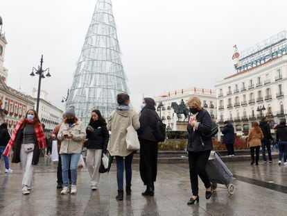 Varias personas caminan con mascarillas por la Puerta del Sol este viernes.