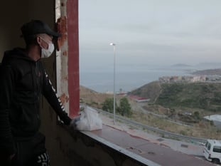 Mohamed mira por una ventana de la cárcel de Los Rosales. En vídeo, el refugio improvisado para inmigrantes en Ceuta.