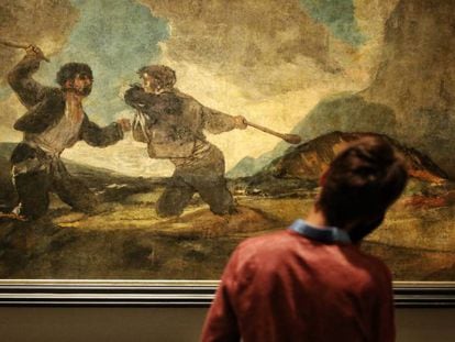 Un visitante contempla la obra &#039;Duelo a garrotazos&#039;, de Goya, en la sala de las pinturas negras del Museo del Prado.